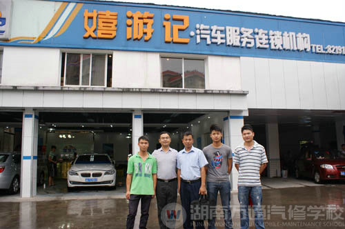 嘻游記汽車服務(wù)連鎖機構(gòu)門口,陸金勇等幾位畢業(yè)學(xué)子與公司老總和陸主管合影