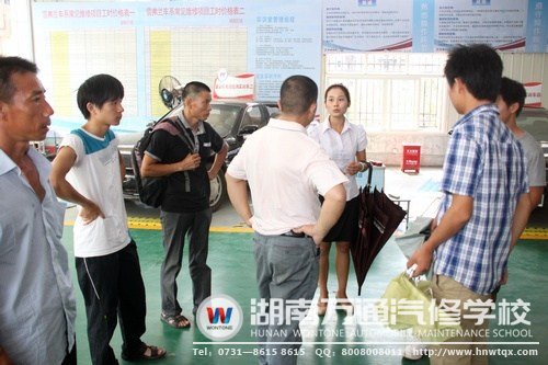 在高級轎車實訓(xùn)中心，咨詢老師給學(xué)生及其家人講述要學(xué)習(xí)的課程