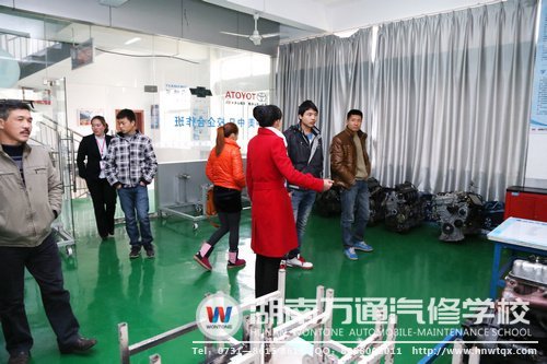 咨詢老師向?qū)W生家長介紹學(xué)校的各類實(shí)訓(xùn)設(shè)備和上課模式